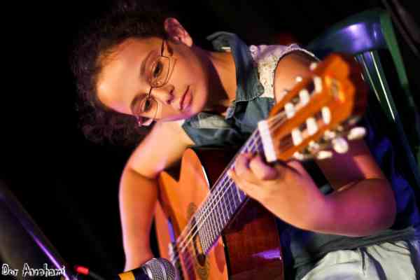 תלמידה לגיטרה בסטודיו די מופיעה על הבמה