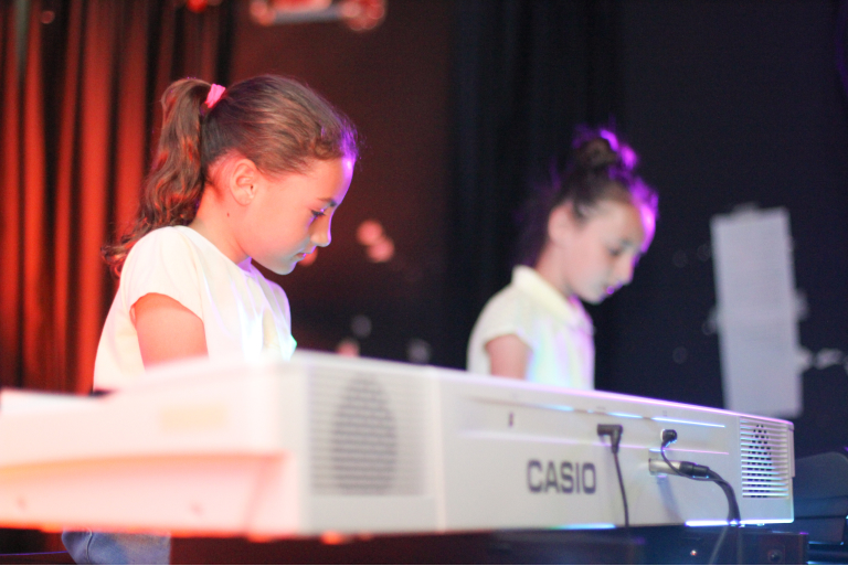 תלמידות לפסנתר בהופעה חיה על הבמה בסטודיו די מנגנות דואט על פסנתר